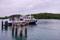 Ferry carrying passengers leaving the pier of St John`s Island. Lush greenery in background. Wide angle shot Royalty Free Stock Photo