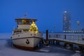 Ferry with Christmas tree standing at edge of bow. Snow covered ship boat is moored at the pier in winter in Schleswig. Schleswig