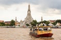 Ferry crossing Chao Phraya River in front of Wat Arun temple in Bangkok