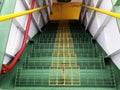 Ferry deck upper to lower level, steel green ladder or stairs with yellow handrails leading down. Royalty Free Stock Photo