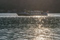 A ferry on Lake Lugano arrives at Porto Ceresio, Italy, from Morcote, Switzerland, in sunset light Royalty Free Stock Photo