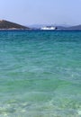 A ferry sails across the Aegean sea against the backdrop of mountains on the island of Evia in Greece