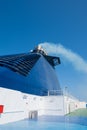 Ferry in the sea and smoke from the chimney against the blue sky. Transport and travel concept