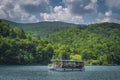 Ferry with tourists on turquoise coloured lake, Plitvice Lakes
