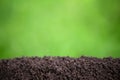 fertile pile of soil with green grass blurred background