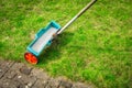 Fertilize lawn - Fertilizer spreader on green lawn Royalty Free Stock Photo