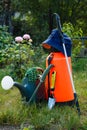 Fertilizer pesticide garden sprayer, watering can and some garden tools on green grass