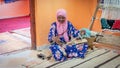 Senior woman spining a woolen string for berber moroccan carpets