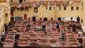 Fes, Morocco - workers soak animal hides on stone vessels with dyes at Chouara Tannery in Fes el Bali. Royalty Free Stock Photo