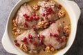 Fesenjan is a simple slowly cooked Iranian stew featuring ground walnuts, pomegranate molasses and chicken thighs close-up in a