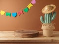 Festa Junina party background with empty podium, cactus and straw hat decoration on wooden table. Brazilian summer harvest