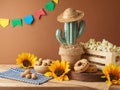Festa Junina party background with popcorn, peanuts and cactus decoration on wooden table. Brazilian summer harvest festival