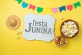 Festa Junina party background with popcorn, peanuts and wooden board. Brazilian summer harvest festival concept. Top view from