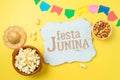 Festa Junina party background with popcorn, peanuts and wooden board. Brazilian summer harvest festival concept. Top view, flat Royalty Free Stock Photo