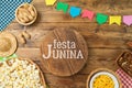 Festa Junina party background with wooden board and traditional food. Brazilian summer harvest festival concept. Top view, flat Royalty Free Stock Photo