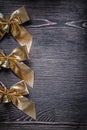 Festal golden bows with bells on wood board Royalty Free Stock Photo