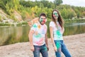 Festival holi, holidays, tourism and nature concept - Couple dressed in white shirts holding cat and covered with Royalty Free Stock Photo