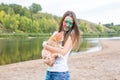 Festival holi, holidays, tourism and nature concept - young woman dressed in white shirt holding cat and covered with Royalty Free Stock Photo