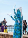 A festival participant dedicated to Purim stands dressed in a fairy statue costume in Caesarea, Israel