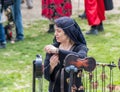 A festival participant dressed in the costume of a medieval lady tries on a man-made bracelet at the Purim festival with King Arth