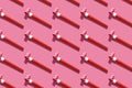 Festive air whistles on pink background. Pattern from elements of Christmas party with hard shadow. Christmas and New
