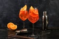 Festive alcoholic cocktail Aperol spritz in glasses on a dark background, concept for bar and New Year\'s Eve, alcoholic