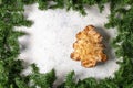 Festive almond pastry in christmas tree shape surrounded by greenery on snowy background Royalty Free Stock Photo
