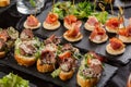 Festive appetizer. Bruschetta range with roasted beef, cherry tomatoes and grated cheese, and also toasted canapes with Royalty Free Stock Photo