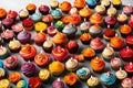 A festive arrangement of multicolored cupcakes adorned with brightly lit candles.