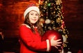 Festive atmosphere christmas day. Girl santa claus costume hold big ball christmas tree ornaments. Christmas decorations Royalty Free Stock Photo