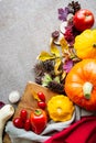 Festive autumn composition from pumpkins, leaves, tomato and squash on the beige background.