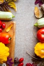 Festive autumn composition from pumpkins, leaves, tomato and squash on the beige background.