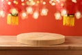 Festive background for Chinese New Year celebration with empty wooden log podium on table and traditional red lanterns. Interior Royalty Free Stock Photo