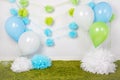 Festive background decoration for first birthday celebration or easter holiday with blue, green and white paper flowers, balloons