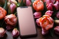 Festive background hosts mobile phone and spring tulips in a flat lay