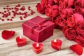 Festive background to the Valentine`s day. A bouquet of red roses, a gift box and a heart-shaped candle. Royalty Free Stock Photo