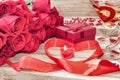 Festive background to the Valentine`s day. A bouquet of red roses, a gift box, a heart-shaped candle and a red ribbon with a heart Royalty Free Stock Photo