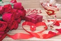Festive background to the Valentine`s day. A bouquet of red roses, a gift box, a heart-shaped candle and a red ribbon with a heart Royalty Free Stock Photo