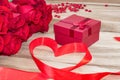 Festive background to the Valentine`s day. A bouquet of red roses, a gift box, a heart-shaped candle and a red ribbon with a heart Royalty Free Stock Photo