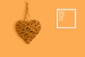 Festive background with wooden heart on marigold orange background for Valentine\'s Day. Flatlay. Top view