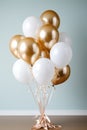 Festive balloons in pale metallic gold and white in a bouquet or bundle