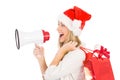 Festive blonde holding megaphone and bags Royalty Free Stock Photo