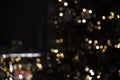 festive blurred urban bokeh background with glowing garlands of yellow and blue against night sky