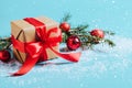 Festive box with a red bow close-up on a blue background with Christmas toys balls a branch of fluffy spruce sparkles Royalty Free Stock Photo