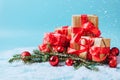 Festive box with a red bow close-up on a blue background with Christmas toys balls a branch of fluffy spruce sparkles Royalty Free Stock Photo