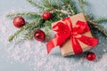 Festive box with a red bow close-up on a blue background with Christmas toys balls a branch of fluffy spruce sparkles Royalty Free Stock Photo