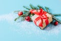 Festive box with a red bow close-up on a blue background with Christmas toys balls a branch of fluffy spruce sparkles Royalty Free Stock Photo