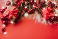 Festive boxes with a satin red bow on a red background with Christmas toys balls, a branch of fluffy fir tree, sparkles Royalty Free Stock Photo