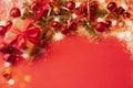 Festive boxes with a satin red bow on a red background with Christmas toys balls, a branch of fluffy fir tree, sparkles Royalty Free Stock Photo