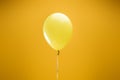 Festive bright minimalistic decorative balloon on yellow background.